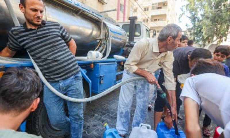 חלוקת מים ממכולה לתושבי הרצועה [צילום: עטיה מוחמד/פלאש 90]