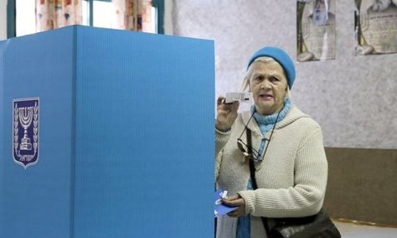 מצביעה בקלפי מציגה למצלמה את פתק ההצבעה [צילום: AP]