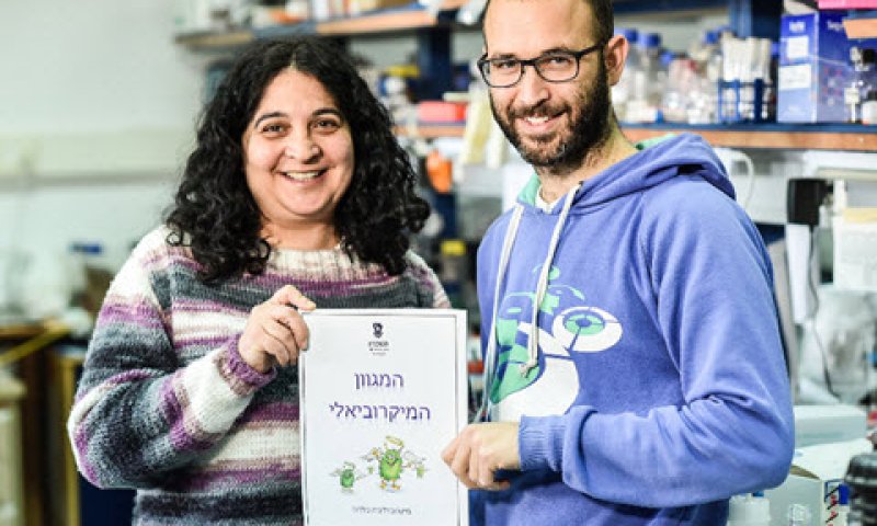 פרופ' סימה ירון והסטודנט רותם פוטוק עם ספר היצירות של המגוון המיקרוביאלי [צילום: ניצן זוהר, דוברות הטכניון ]