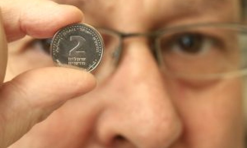 מרדכי פיין ממחלקת המטבע של בנק ישראל בוחן את המטבע החדש [צילום: פלאש 90]