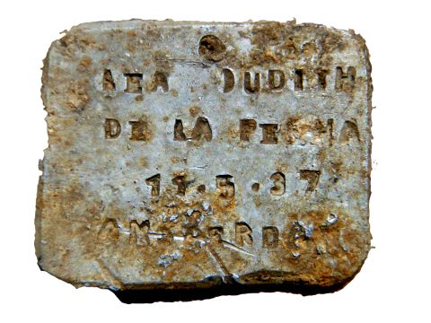 תליון אלומיניום שעליו חריטה, נמצא באזור רציף המחנה. שם פרטי - Lea Judith, שם המשפחה De La Penha, תאריך הלידה 11.5.37, AMSTERDAM [צילום: יורם חיימי]