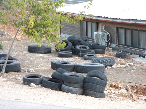 מצבורי צמיגים מאחורי בית הכנסת המקומי [צילום: איציק וולף]