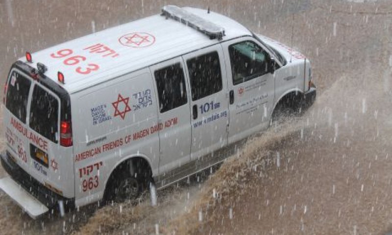 אמבולנס מד"א בנסיעה בגשם בפתח תקווה [צילום: ברוך הופמן דוברות מדא ]