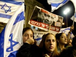 "אני מצפצף על כולכם". שלט בהפגנה