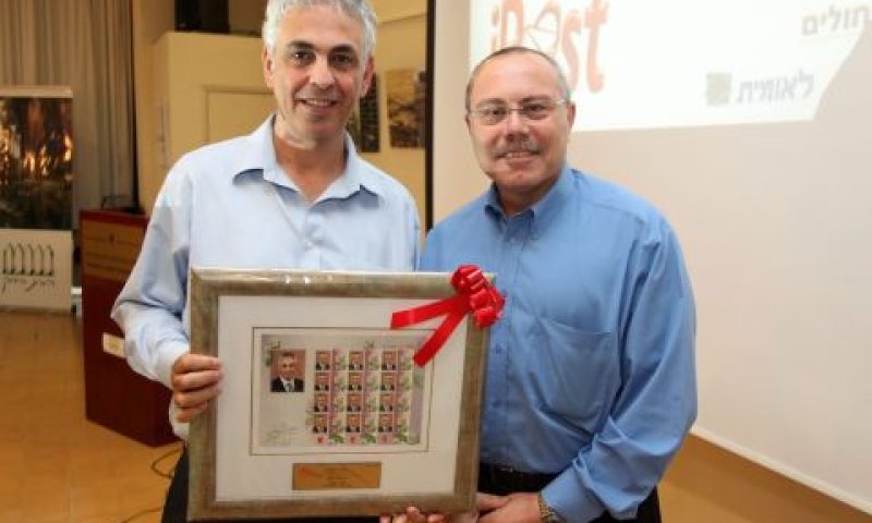 אבי הוכמן מנכ"ל דואר ישראל, מעניק לאורי ערד - מנכ"ל מלם מערכות מקבוצת מלם-תים, שי: סדרת בולים עם דיוקנו של אורי ערד [צילום: יח"צ]