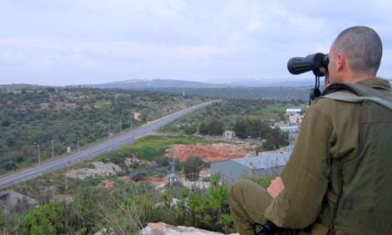 תצפיתן צופה במשקפת על כפר עזון [צילום: פלאש 90]