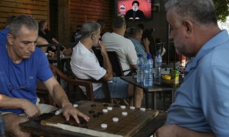 יושבי בית קפה בביירות וברקע נאום נסראללה [צילום: בילאל חוסיין/AP]