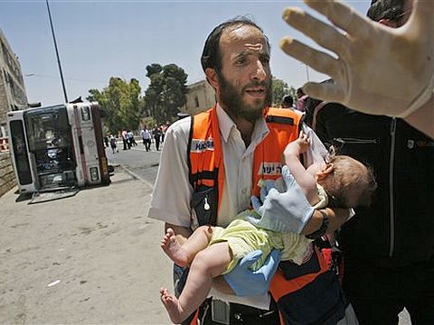 אפרת אונטרמן בידי פראמדיק שחילץ אותה ממקום הפיגוע [צילום: AP]