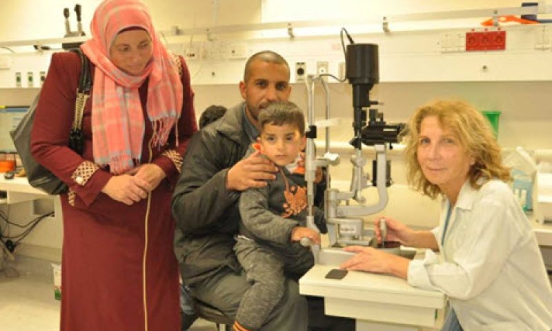 פרופ' גייר בודקת את התינוק עבדלחי יחד עם הוריו בכרמל [צילום: אלי דדון]