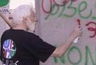 ומתי הוא יועמד לדין? אורי אבנרי מרסס גרפיטי על גדר ההפרדה [צילום ארכיון]