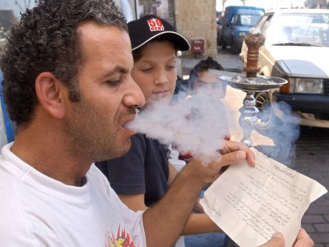 תושב בצידון קורא עלון שפוזר ממטוס ישראלי [AP]