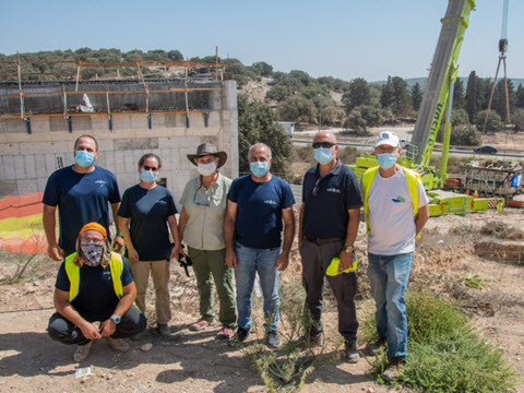 צוות רשות העתיקות ותושבי חנתון על רקע מקווה הטהרה [צילום: יניב ברמן, רשות העתיקות]