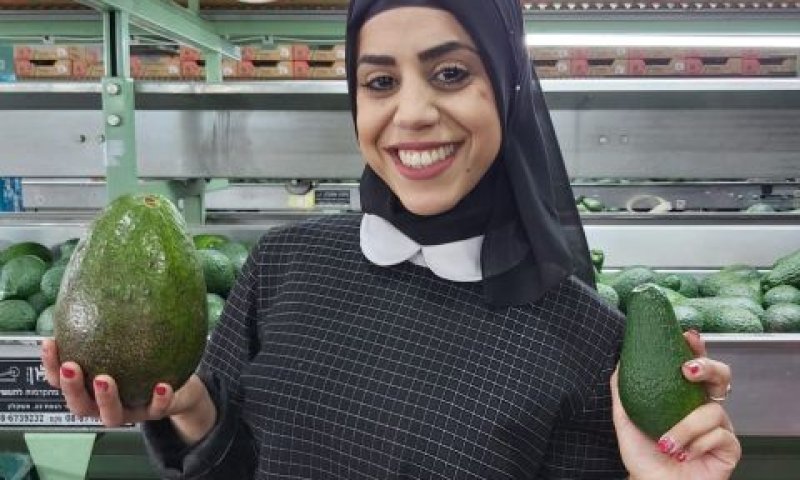 עובדת בית האריזה, דועא אבו-לבדה, מחזיקה את האבוקדו [צילום: אחיקם חיים]