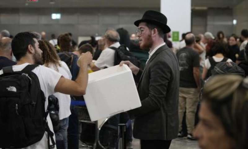 נמל התעופה הבינלאומי אלפתריוס וניזלוס באתונה. בחור מחלק כריכים לישראלים העולים לטיסות ארצה [צילום: תנאסיס סטברוקיס/AP]