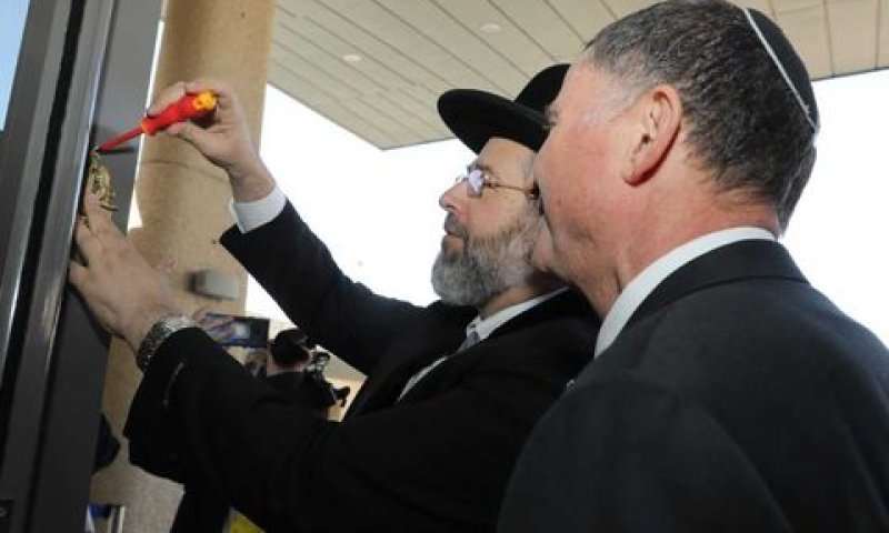 הרב לאו קובע מזוזה [צילום ארכיון: דוברות הכנסת]