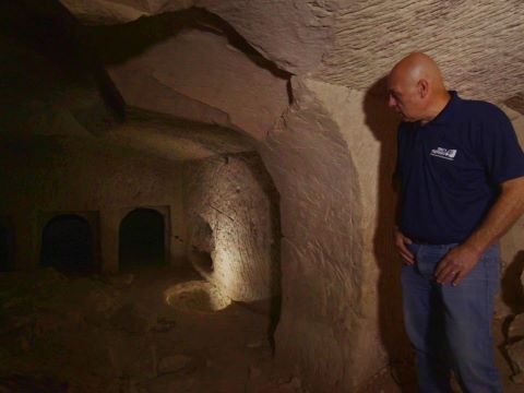 מנהל החפירה, צבי פירר, בפתח מערת הקבורה [צילום: אמיל אלג'ם, רשות העתיקות]