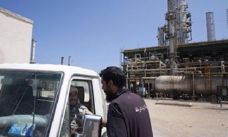 מורדים משוחחים עם פועל במתקן נפט בלוב [צילום: AP]