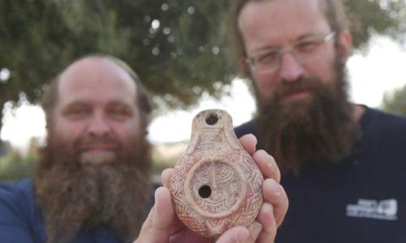 החוקרים מיכאל טשרנין ובנימין סטורצ'ן עם הנר הנדיר [צילום: אמיל אלג'ם, רשות העתיקות]