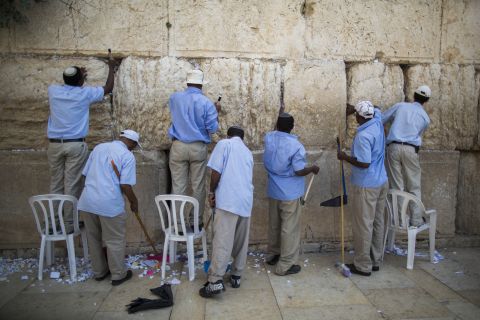 פועלים מוציאים פתקים מהכותל [צילום: פלאש 90]