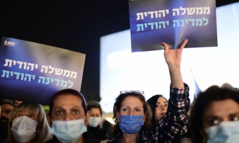 מפגינים נושאי שלטים בכיכר [צילום: תומר נויברג/פלאש 90]